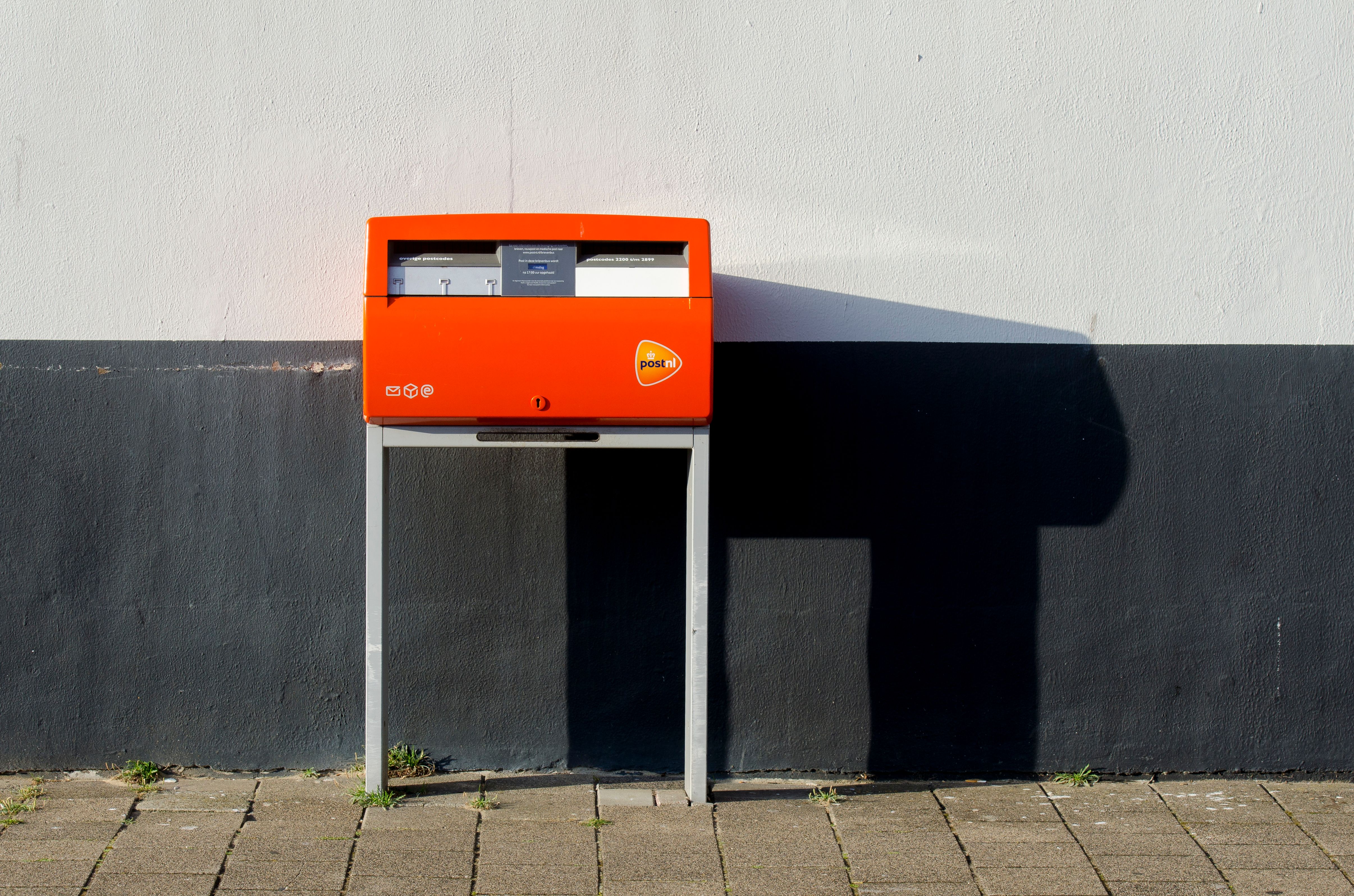 Een oranje PostNL-brievenbus aan de straat