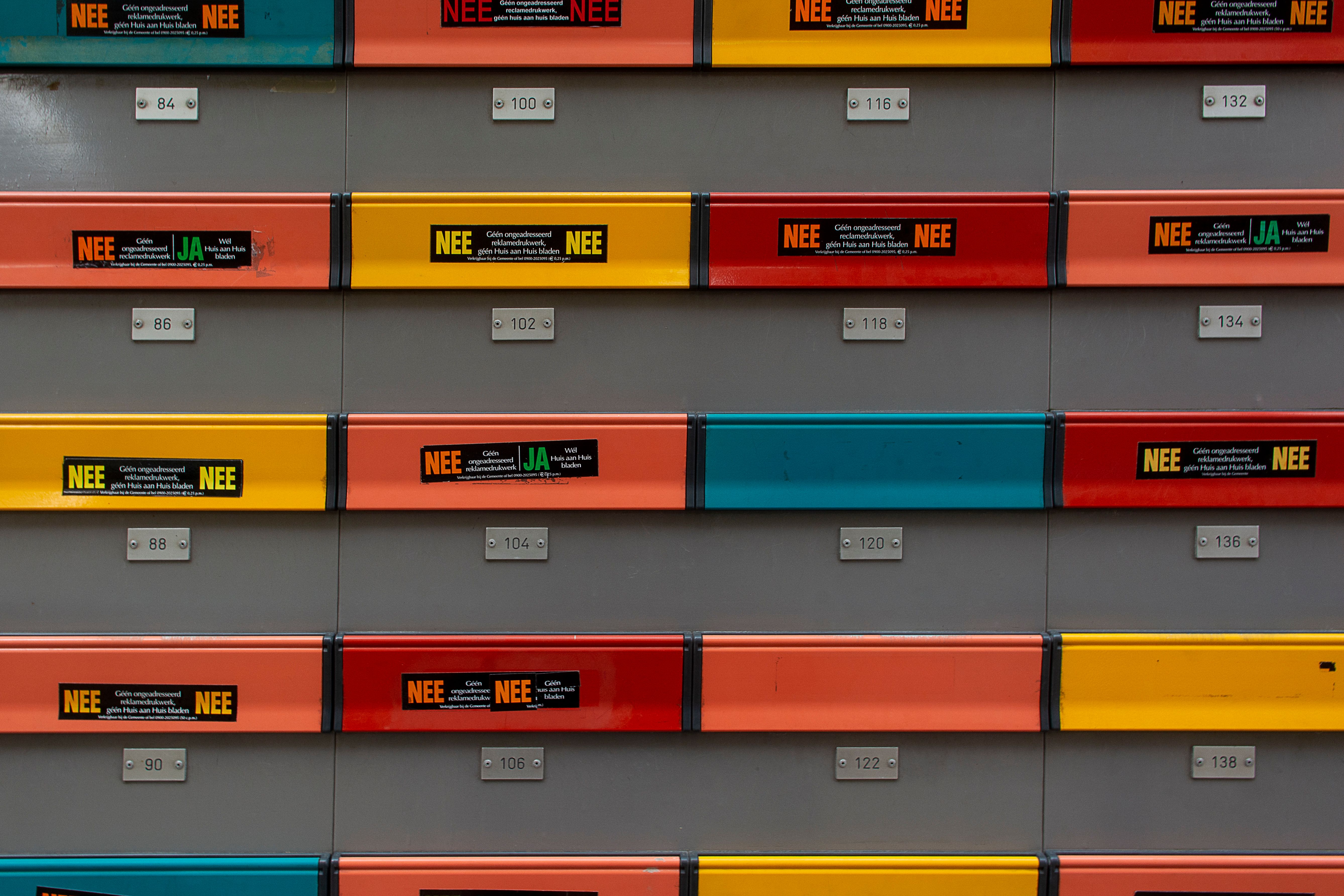 Een wand met vrolijk gekleurde brievenbussen